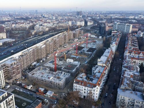 Blick von oben auf die Baustelle des Großprojektes im Rohbau mit Kränen